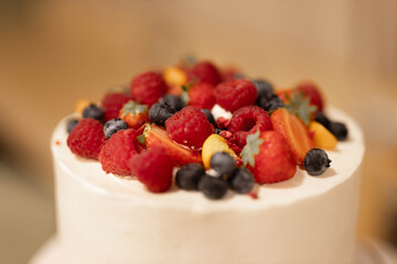 ripe red berries strawberries and raspberries on white wedding cake