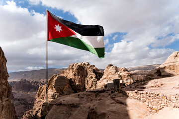 The flag of Jordan blowing in the wind in Petra, Jordan. Three-color flag of Jordan on the...