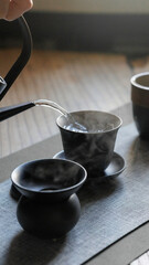 A traditional tea brewing setup showcasing elegant black ceramics for a peaceful ritual