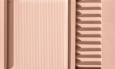 Mocha Mousse background Color of 2025 year. Beige exterior stucco wall with repeating details and blinds at the top. Rough surface in the sun with shadows. Rough texture and background for design. 
