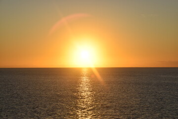 Stunning Pacific Ocean sunset with beams of colourful light shining up from the sea and islands in Fiji