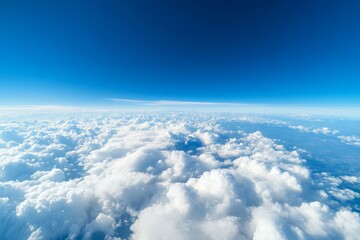 Fototapeta premium Expansive view above bright white clouds on a clear blue sky during daytime
