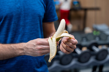 Close-up of young man eating banana during gym workout break  © marta