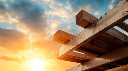A stack of wooden beams is silhouetted against a stunning sunrise, creating a warm and rustic scene of construction elements in nature's glow.
