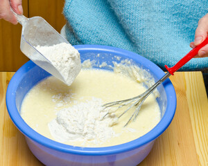Making pancake batter. Pouring flour.