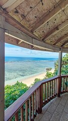 A wooden porch / balcony in a tropical cabin overlooking the turquoise Pacific Ocean and corals in Tonga