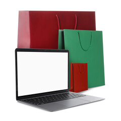 Laptop and shopping bags isolated on white. Concept of online shopping, purchase via internet