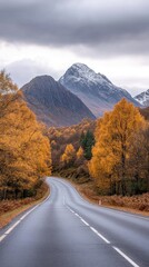 A wide road stretches through vibrant fall foliage and majestic mountains under a serene sky. The scene captures the beauty of nature during autumn.
