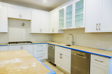 Newly remodeled kitchen features white cabinets, stainless steel appliances, an unfinished countertop.