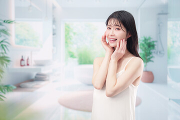 家でスキンケアをする若い女性