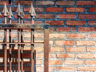 Minimal style image of a vintage old red brick wall background and an iron fence with space for text.