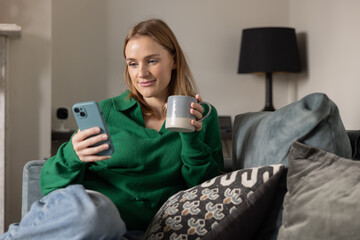 Young adult woman at home paying bills and personal finances with a phone