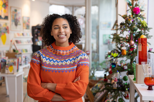 Small business owner looking out of store window planning business growth at Christmas