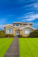 Two story stucco luxury house with nice summer  landscape in Vancouver, Canada, North America. Day time on June 2024.