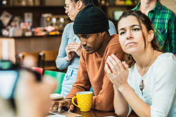 Diverse university students working on project in cafe using laptop