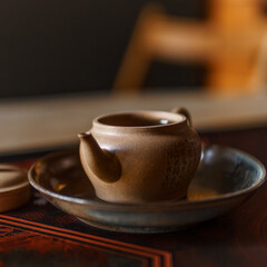 An Elegant Teapot gracefully resting on a Saucer surrounded by a Warm and Inviting Atmosphere