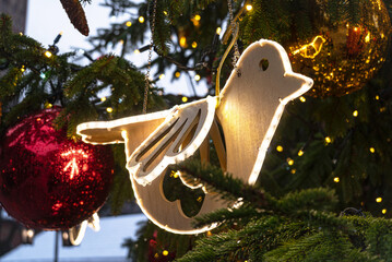 Close up view of the wooden bird decoration of the Christmas tree under the lights