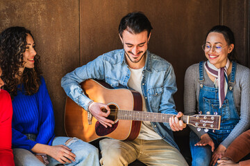 Young man playing acoustic guitar for friends