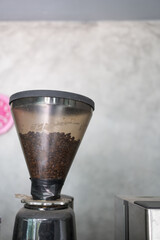 Obraz premium Coffee beans in coffee grinder machine at cafe
