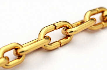 Fototapeta premium A polished gold chain lies flat, displaying the smooth links and reflections in bright light, emphasizing its quality