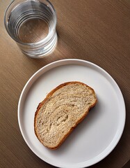 A slice on the plate with a glass of water Topic Poverty, old age poverty or a Dlät