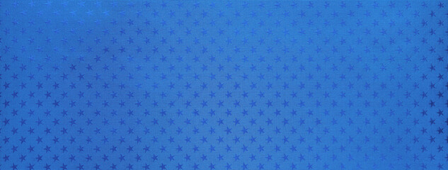 Blue christmas background, metal foil paper with pattern stars, macro. Abstract sapphire wrapping backdrop