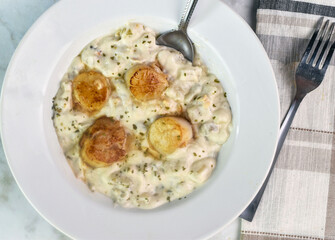 clam chowder top  with herbs and scallops