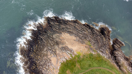 Aerial view of sea waves on coastal rocks