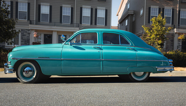 Vintage Packard car parked on the city street. A classic Packard car 1949 turquoise color outdoor.