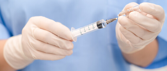 nurse draws medicine from an ampoule into a syringe