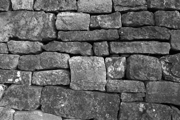 Obraz premium Rustikale Trockenmauer bedeckt mit grünem Efeu. Natürliche Textur und Struktur, ideal als Hintergrund für Präsentationen, Werbung und Banner. Schöne Verbindung von Natur und Architektur