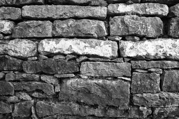 Rustikale Trockenmauer bedeckt mit grünem Efeu. Natürliche Textur und Struktur, ideal als Hintergrund für Präsentationen, Werbung und Banner. Schöne Verbindung von Natur und Architektur