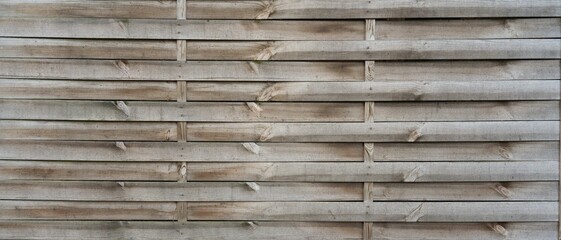Holzzaun mit geometrischem Muster und nat&uuml;rlicher Holzstruktur. Ideal als Hintergrund f&uuml;r Pr&auml;sentationen, Werbung und Banner. Sch&ouml;ne Verbindung von Natur und Design