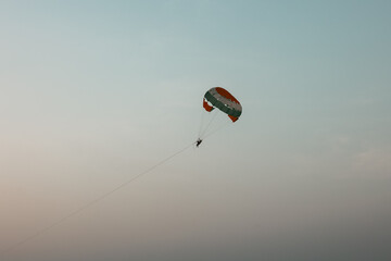 Goa beach Parasailing extreme sports on beach in blue sky background. Parasailing activity on beautiful beach during the day parachute like flying