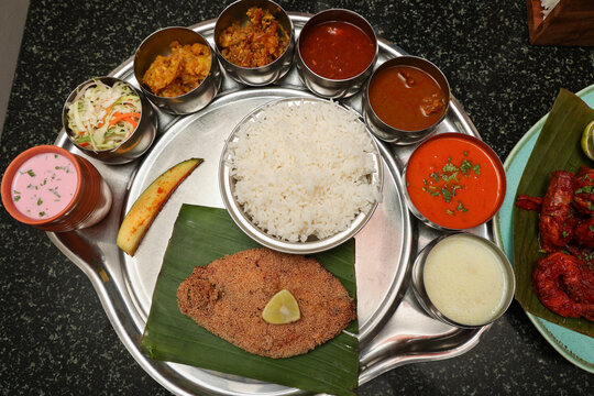 Goa Goan Fish Thali rice served with rawa fried seer fish, Sol Kadi Solkadhi Kokum curry Top View. Indian Fish Platter thali Popular sea food Non vegetarian meal Mumbai Konkan Maharashtra prawns 65
