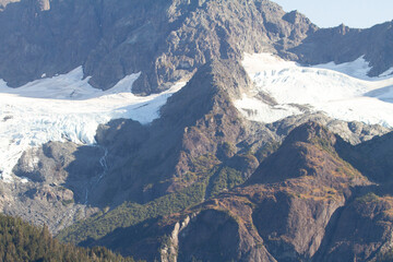 Majestic mountain landscape with snow-capped peaks and rocky terrain under a clear sky.