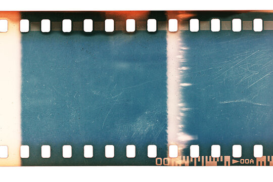 Dusty and grungy 35mm film texture or surface. Perforated scratched camera film isolated on white background.