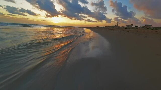 FPV drone flying fast along a beach