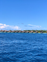 Fototapeta premium Water villa and resort in Maafushi island, Maldives - Sunny and beautiful holiday vacation in the Indian Ocean, surrounding by amazing crystal clear water and the sea and the beach 