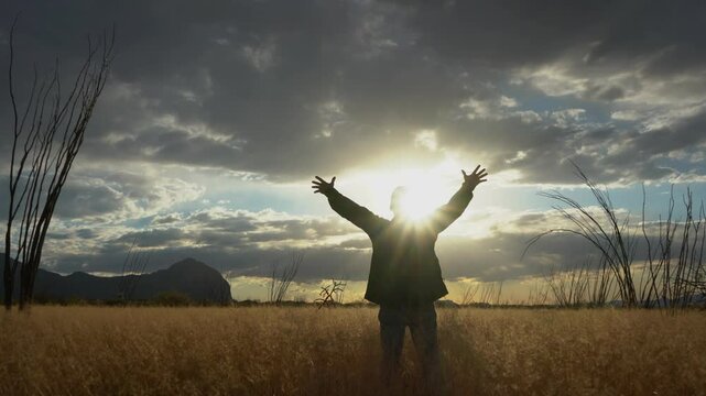 A Christian man praising God in nature at sunset