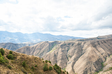 Majestic mountains under a blue sky filled with clouds, showcasing natural beauty and rugged terrain