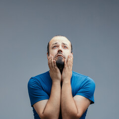 Worried and anxious man holding his face in his hands