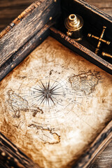 Fototapeta premium Old map with a compass rose and detailed continents on display at a museum showcasing history and exploration
