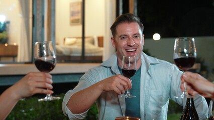 Family together for holiday celebration. Adult member drinking wine with glass to celebrate. Outdoor camping activity relax with food and spend time with relatives cross generation gap. Divergence.