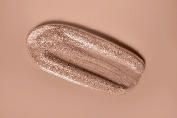 Transparent lip gloss tint with sparkles in mocha mousse color