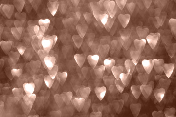 Hearts, sparkling bokeh, abstract defocused background in 2025 color mocha mousse