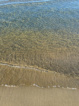 Sea clear waves on sand beach.