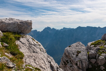 On top of mount Cima Del Lago overlooking majestic mountain ridges of Julian Alps, border Italy Slovenia. Climbing on rocky summit in Triglav National Park. Alpine wilderness in summer. Wanderlust