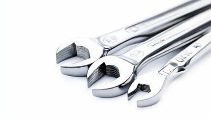 Three shiny metal wrenches, overlapping, white background.
