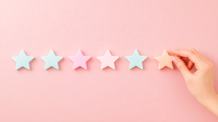 Colorful stars arranged in a row on a pastel pink background during a creative craft session
